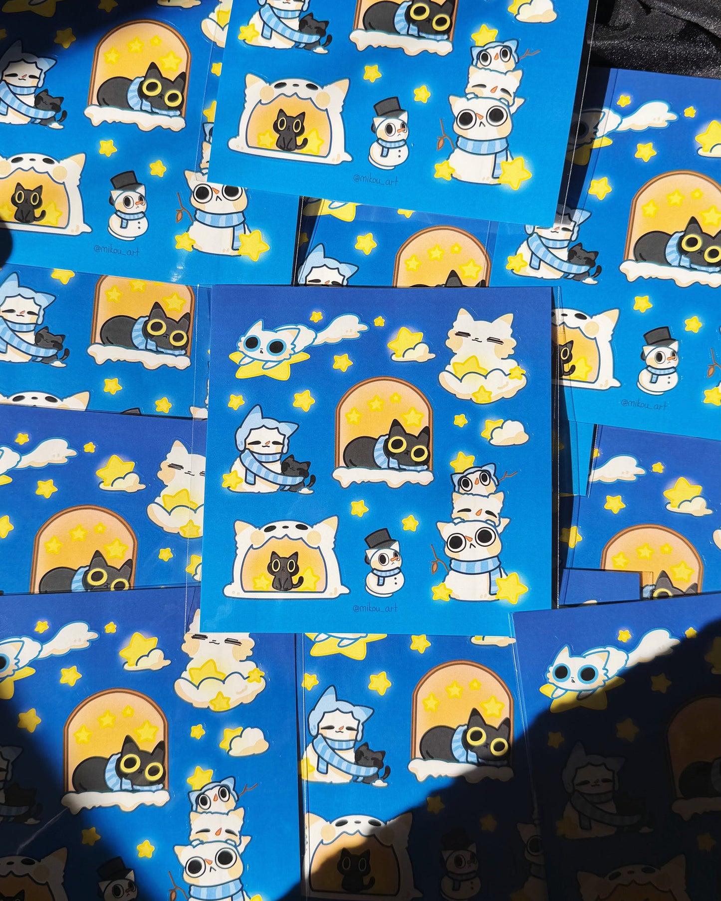 Collection of blue stickers with cartoon cat designs on a dark background